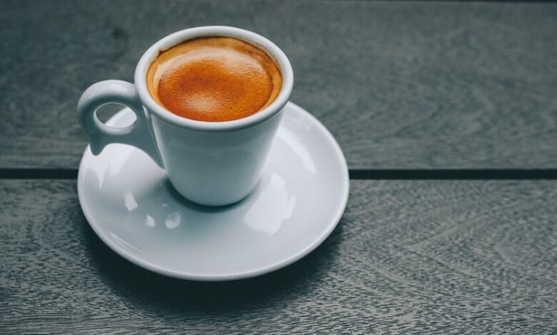 Taza de café humeante sobre una mesa de madera