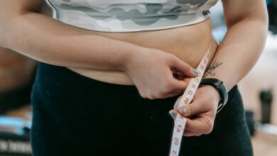 Persona midiendo su cintura mientras sigue una dieta de bajo consumo calórico