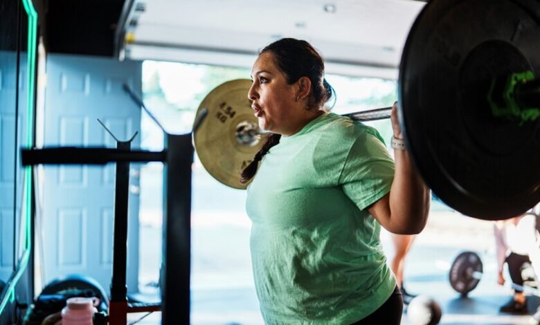Persona entrenando en gimnasio con pesas, ilustrando la sobrecarga progresiva