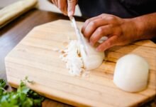 Cebolla con brotes verdes sobre una tabla de madera