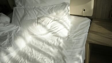 Habitación con cama deshecha y persianas abiertas para ventilar