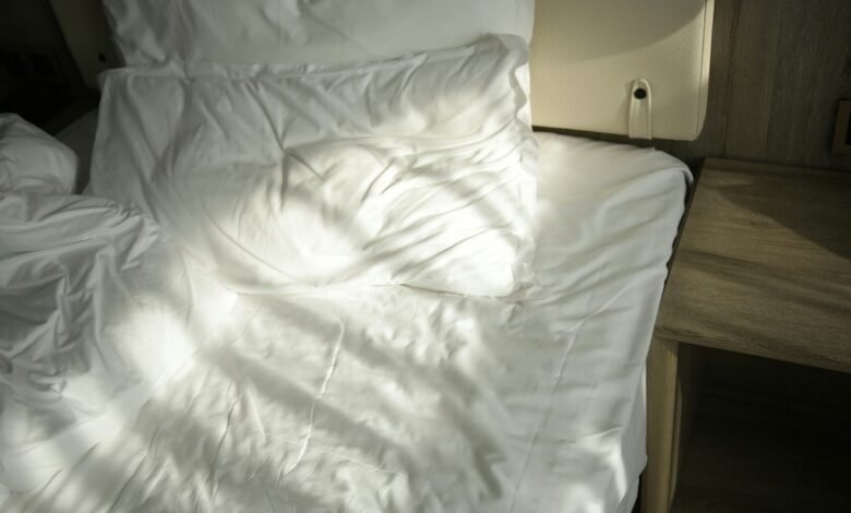 Habitación con cama deshecha y persianas abiertas para ventilar
