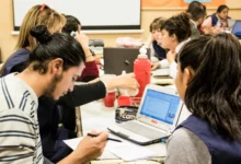 Jóvenes cordobeses ingresando a una universidad pública con la bandera de la provincia de fondo