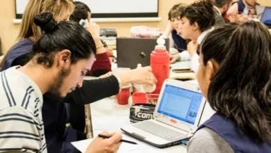 Jóvenes cordobeses ingresando a una universidad pública con la bandera de la provincia de fondo