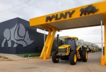 Planta de fabricación de tractores Pauny en Las Varillas, Córdoba, con filas de máquinas y personal en la zona de carga.