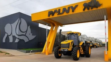 Planta de fabricación de tractores Pauny en Las Varillas, Córdoba, con filas de máquinas y personal en la zona de carga.
