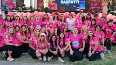 Participantes de la caminata 'Caminamos con vos' recorriendo el Parque Sarmiento bajo el lazo rosa