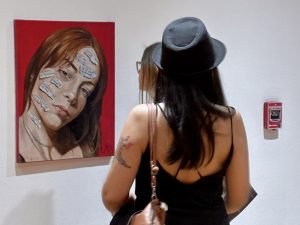 Jóvenes artistas exhibiendo sus obras en el Museo Emilio Caraffa durante el Festival Nuestro Arte es Trabajo